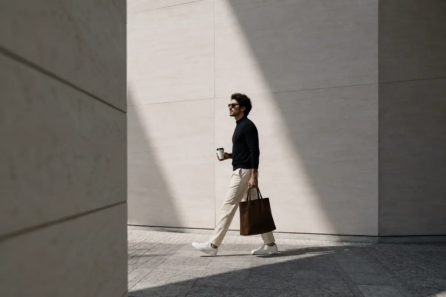 Man walking confidently in sunlight with a coffee and bag representing financial security