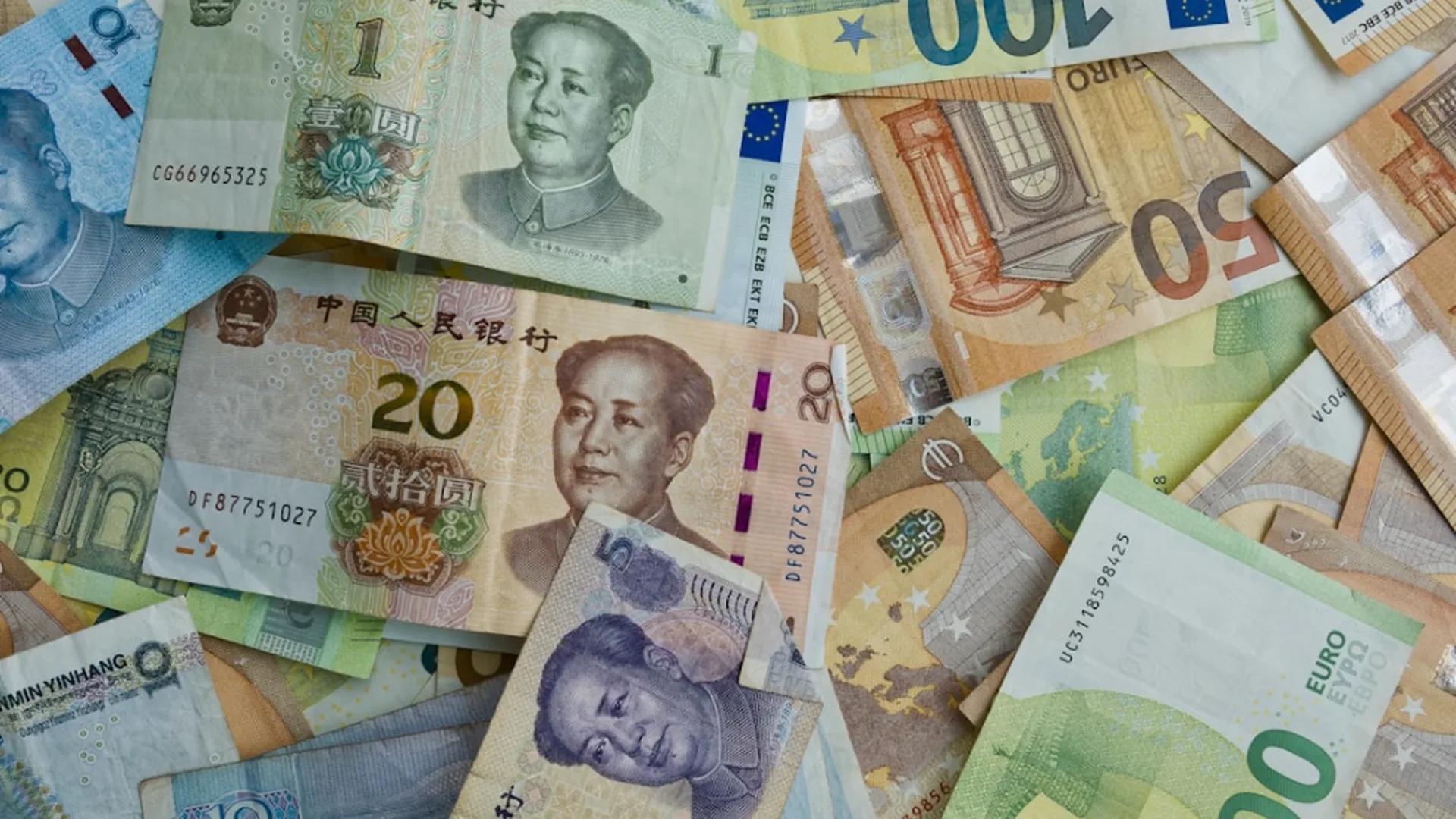 Pile of international banknotes from multiple countries spread across a flat surface